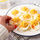 stuffed eggs with paprika, on a plate, a woman's hand reaches for it, stuffed eggs with paprika, on a plate, a woman's hand reaches for it, - PhotoDune Item for Sale