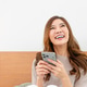 Joyful woman looking at phone with excitement Joyful woman looking at phone with excitement - PhotoDune Item for Sale