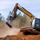 Excavator working on construction site clearing land for development in forested area Excavator working on construction site clearing land for development in forested area - PhotoDune Item for Sale