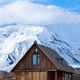 Wooden Cabin in Valley Below Massive Snowy Mountains Wooden Cabin in Valley Below Massive Snowy Mountains - PhotoDune Item for Sale
