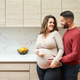Loving couple expecting baby, embracing pregnancy in kitchen Loving couple expecting baby, embracing pregnancy in kitchen - PhotoDune Item for Sale