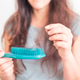 A girl holds dry, fallen hair with a comb after combing. The problem of hair loss and breakage A girl holds dry, fallen hair with a comb after combing. The problem of hair loss and breakage - PhotoDune Item for Sale