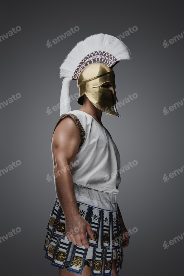 Ancient greek soldier with tunic and golden helmet with plume