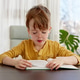 Kid sitting on chair reading a book, wearing glasses Kid sitting on chair reading a book, wearing glasses - PhotoDune Item for Sale