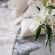 White lilies in a vase on the bedside table. White lilies in a vase on the bedside table. - PhotoDune Item for Sale