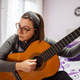 Woman playing acoustic guitar at home in bedroom Woman playing acoustic guitar at home in bedroom - PhotoDune Item for Sale