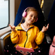 A girl on a train listens to music in headphones with a gadget in her hands. A girl on a train listens to music in headphones with a gadget in her hands. - PhotoDune Item for Sale