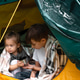 Couple of children drinking hot beverage in tent. Concept of camping or refugeeism Couple of children drinking hot beverage in tent. Concept of camping or refugeeism - PhotoDune Item for Sale