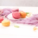 Assorted Macarons with Honeysuckle Flowers and Purple Fabric on White Wood Assorted Macarons with Honeysuckle Flowers and Purple Fabric on White Wood - PhotoDune Item for Sale