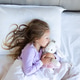 Young girl sleeping in bed while hugging a stuffed animal toy Young girl sleeping in bed while hugging a stuffed animal toy - PhotoDune Item for Sale