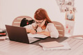 Teen girl in eyeglasses sitting at table and using notebook. Home tasks, distant education. Writing Teen girl in eyeglasses sitting at table and using notebook. Home tasks, distant education. Writing - PhotoDune Item for Sale