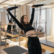Wooden Pilates Cadillac trapeze table with model exercising Wooden Pilates Cadillac trapeze table with model exercising - PhotoDune Item for Sale