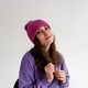 Beautiful young woman in a purple hat and sweatshirt on a plain gray background in a photo studio. Beautiful young woman in a purple hat and sweatshirt on a plain gray background in a photo studio. - PhotoDune Item for Sale