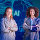 Two women stand together in suits at a technology event showcasing artificial intelligence Two women stand together in suits at a technology event showcasing artificial intelligence - PhotoDune Item for Sale