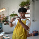 Young man in yellow apron inspecting a handcrafted ceramic plate in a pottery studio Young man in yellow apron inspecting a handcrafted ceramic plate in a pottery studio - PhotoDune Item for Sale