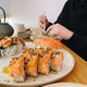 Man is eating sushi rolls with salmon by food sticks at the restaurant. Asia food. Serving food. Man is eating sushi rolls with salmon by food sticks at the restaurant. Asia food. Serving food. - PhotoDune Item for Sale