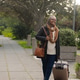 Senior African American woman wearing coat walking on paved path pulling carryon and carrying bag Senior African American woman wearing coat walking on paved path pulling carryon and carrying bag - PhotoDune Item for Sale