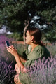 Young woman holding phone and making photos for social webs in summer lavender blooming field Young woman holding phone and making photos for social webs in summer lavender blooming field - PhotoDune Item for Sale
