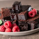 Chocolate cake and fresh raspberries on a rustic plate. Brownie cake. Chocolate cake and fresh raspberries on a rustic plate. Brownie cake. - PhotoDune Item for Sale