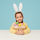Adorable girl in bunny ears sitting with basket of eggs Adorable girl in bunny ears sitting with basket of eggs - PhotoDune Item for Sale