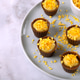 Chocolate cups with open mango filling and orange crunch sprinkles on a ceramic plate Chocolate cups with open mango filling and orange crunch sprinkles on a ceramic plate - PhotoDune Item for Sale