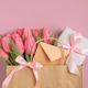 Gift Bag with Pink Tulips and Gift Box on Pink Background. Valentines or Mothers Day Celebration Gift Bag with Pink Tulips and Gift Box on Pink Background. Valentines or Mothers Day Celebration - PhotoDune Item for Sale