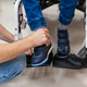 Parent assisting child with disability wearing orthopedic shoes Parent assisting child with disability wearing orthopedic shoes - PhotoDune Item for Sale