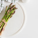 Bundle of fresh asparagus tied with twine on round white wooden tray Bundle of fresh asparagus tied with twine on round white wooden tray - PhotoDune Item for Sale