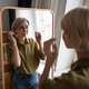 Beautiful middle aged woman looks in mirror with satisfied expression on new haircut and clothing Beautiful middle aged woman looks in mirror with satisfied expression on new haircut and clothing - PhotoDune Item for Sale