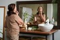 Portrait of senior woman taking care of her skin, looking at mirror Portrait of senior woman taking care of her skin, looking at mirror - PhotoDune Item for Sale