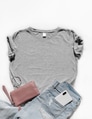 Gray t-shirt with jeans and leather pink feminine bag above white background. Gray t-shirt with jeans and leather pink feminine bag above white background. - PhotoDune Item for Sale