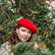 A woman in a red clothes with a bouquet of fir branches walks along the Christmas decorated streets A woman in a red clothes with a bouquet of fir branches walks along the Christmas decorated streets - PhotoDune Item for Sale