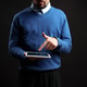 Man in blue sweater using tablet while standing against a dark background in a modern setting Man in blue sweater using tablet while standing against a dark background in a modern setting - PhotoDune Item for Sale