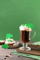 Irish coffee in green cup and cupcakes for St Patricks Day on green background. Irish coffee in green cup and cupcakes for St Patricks Day on green background. - PhotoDune Item for Sale