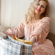 A blonde in a long pink dress poses by the window unwrapping gifts on International Women's Day. A blonde in a long pink dress poses by the window unwrapping gifts on International Women's Day. - PhotoDune Item for Sale