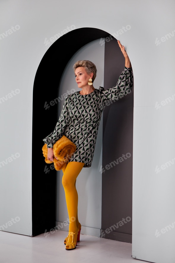 Beautiful slim mature woman short hairstyle stands posing in mini dress. Fashion stylish clothes Stock Photo by annazzhuk Beautiful slim mature woman short hairstyle stands posing in mini dress. Fashion stylish clothes Stock Photo by annazzhuk