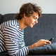 Young man lying on sofa at home and looking at cellphone Young man lying on sofa at home and looking at cellphone - PhotoDune Item for Sale