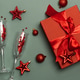 Champagne Flutes, Gift Box and Red Christmas Decorations on Green Background Champagne Flutes, Gift Box and Red Christmas Decorations on Green Background - PhotoDune Item for Sale
