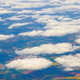 Scenic view of white clouds over green brown farmland from an airplane window Scenic view of white clouds over green brown farmland from an airplane window - PhotoDune Item for Sale