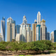 Dubai skyline with luxury skyscrapers and green park trees under a blue sky Dubai skyline with luxury skyscrapers and green park trees under a blue sky - PhotoDune Item for Sale