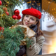 A woman in a red clothes with a bouquet of fir branches walks along the Christmas decorated streets A woman in a red clothes with a bouquet of fir branches walks along the Christmas decorated streets - PhotoDune Item for Sale