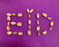 The word EID written using pistachio nuts on purple background The word EID written using pistachio nuts on purple background - PhotoDune Item for Sale