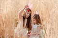 Two little girls sisters sitting in wheat field collecting red eggs in basket. Celebrating Easter Two little girls sisters sitting in wheat field collecting red eggs in basket. Celebrating Easter - PhotoDune Item for Sale