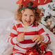 little curly cute girl in Christmas pajamas eats lollipop and tangerines sitting in bed. lifestyle little curly cute girl in Christmas pajamas eats lollipop and tangerines sitting in bed. lifestyle - PhotoDune Item for Sale