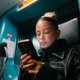 Young woman in a leather jacket focused on her smartphone while sitting inside a modern train. Young woman in a leather jacket focused on her smartphone while sitting inside a modern train. - PhotoDune Item for Sale