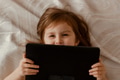 Toddler girl lying in bedroom, using laptop tablet pad gadget, watching with focused face, top view Toddler girl lying in bedroom, using laptop tablet pad gadget, watching with focused face, top view - PhotoDune Item for Sale