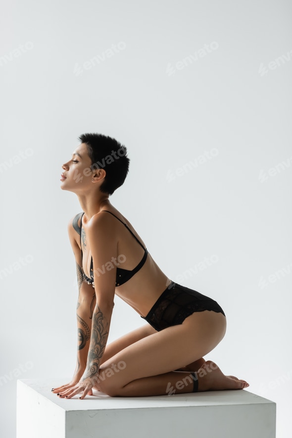 full length of charming and sexy woman with short brunette hair and tattooed body posing Stock Photo by LightFieldStudios full length of charming and sexy woman with short brunette hair and tattooed body posing Stock Photo by LightFieldStudios