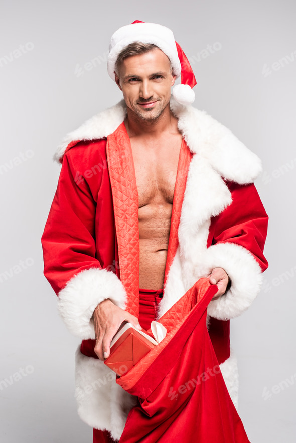 sexy man in santa costume opening red bag and smiling at camera isolated on grey Stock Photo by LightFieldStudios sexy man in santa costume opening red bag and smiling at camera isolated on grey Stock Photo by LightFieldStudios