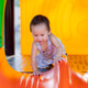 Active toddler crawling and exploring a bright orange slide at an outdoor playground. Active toddler crawling and exploring a bright orange slide at an outdoor playground. - PhotoDune Item for Sale