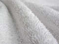 Сloseup of a white towel folds. Texture of white soft terry blanket textile with beautiful folds. Сloseup of a white towel folds. Texture of white soft terry blanket textile with beautiful folds. - PhotoDune Item for Sale